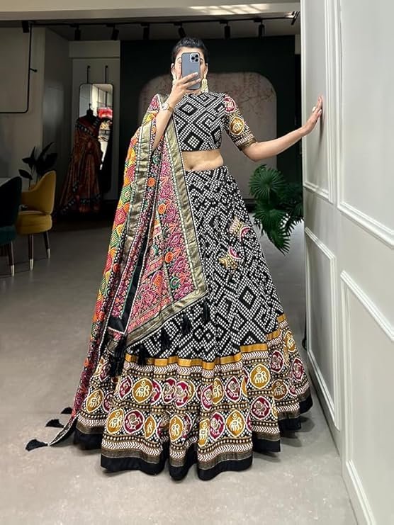 Black and gold designer lehenga featuring a Patola print and foil work on Tussar silk for a trendy yet traditional party look.