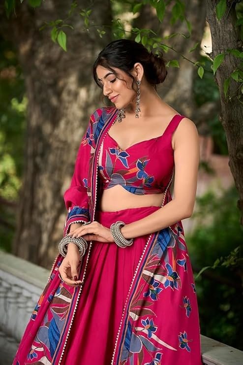 Rani pink designer lehenga choli in Tussar silk with foil printed Patola design for festive wear and wedding functions.