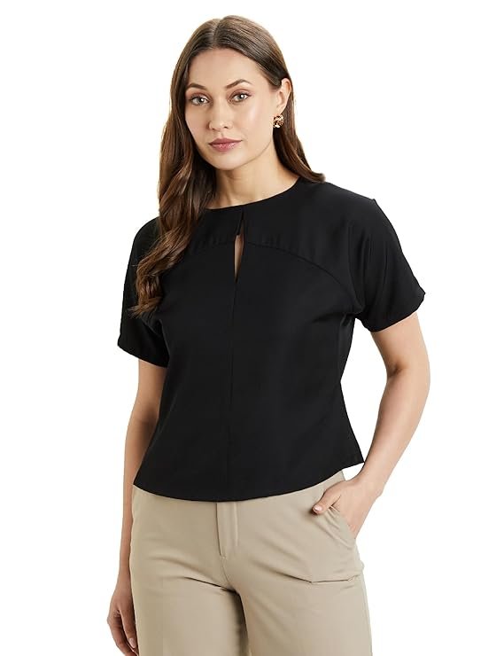 A woman wearing a relaxed fit black desk-to-dinner crop top with half sleeves and a round neck.