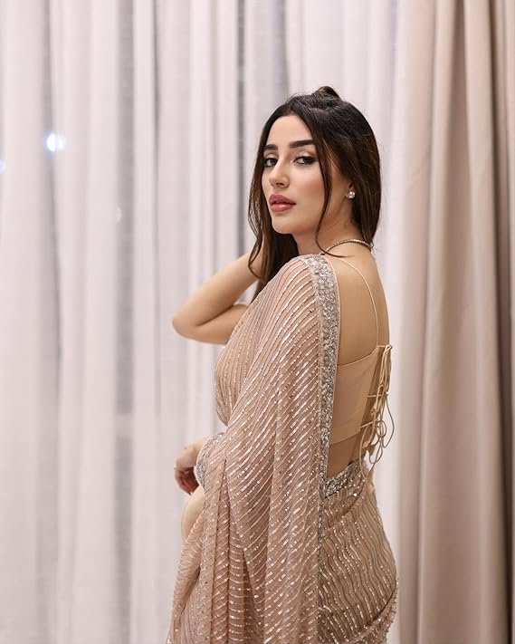 A woman posing in a stunning beige sequin saree with a backless blouse, perfect for a cocktail party. This is a popular style among the best party wear sarees under ₹2000 on Amazon.