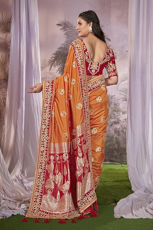 A woman showcasing a vibrant orange and red art silk saree with intricate gold zari weaving, a top choice for traditional events and weddings. This style is often sought after as a designer saree for parties under ₹2000.
